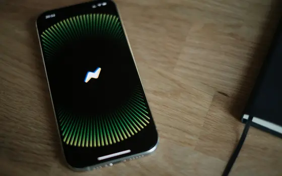 Telefon z animacją asystenta głosowego na drewnianym biurku