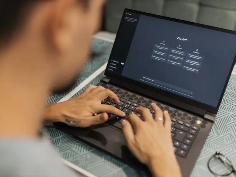 Dłonie na klawiaturze laptopa w półmroku