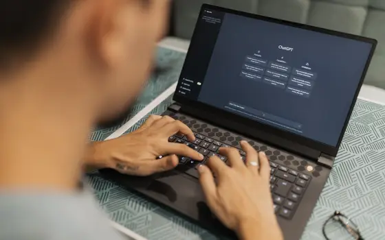 Dłonie na klawiaturze laptopa w półmroku